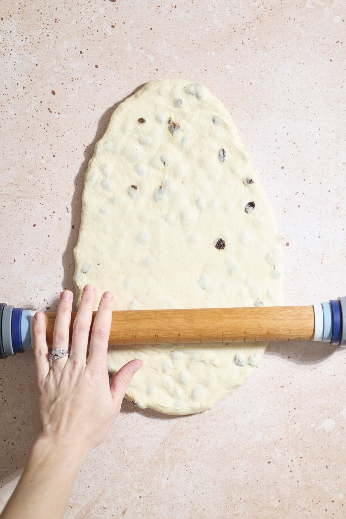 A rolling pin being used to roll out the dough.