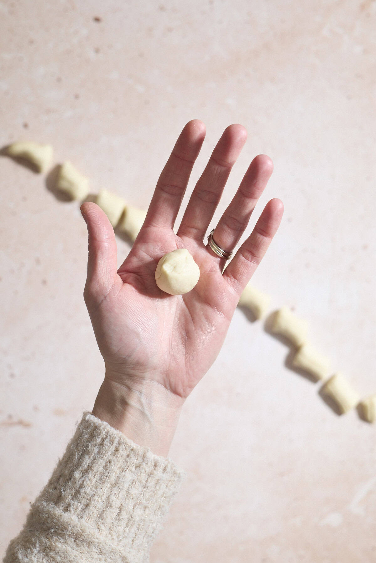 Dough rolled into a ball in the palm of a hand.