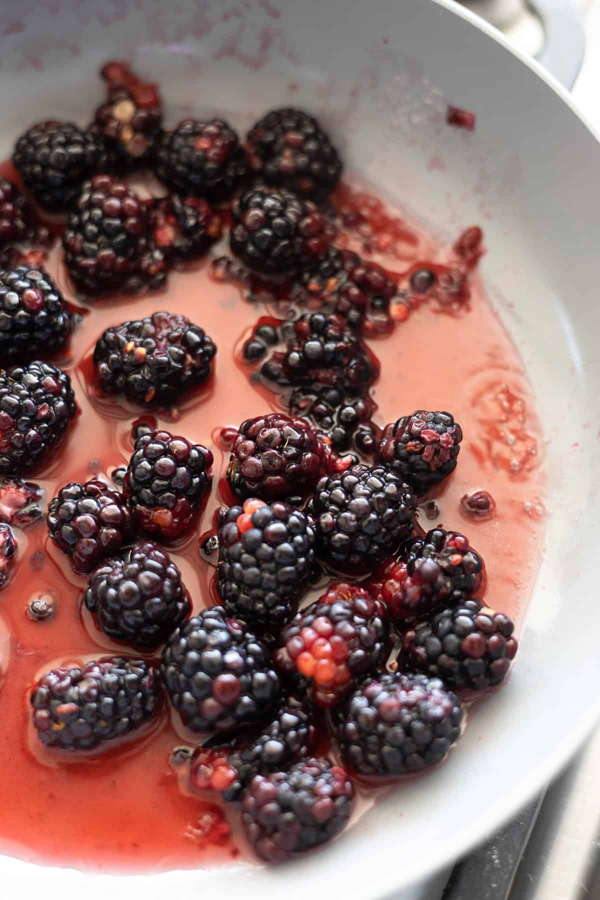 Blackberries simmering in a small skillet.