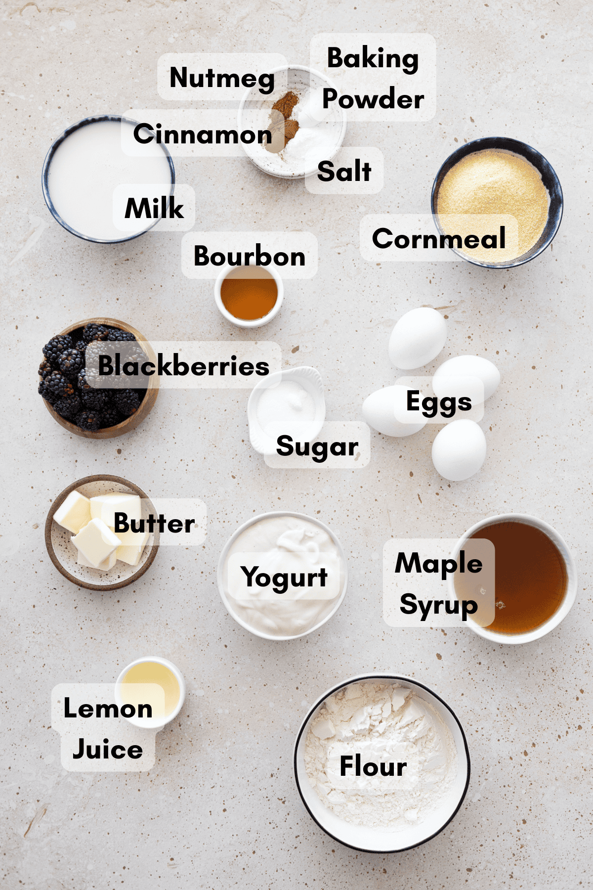 Ingredients for cornmeal waffles in small bowls.