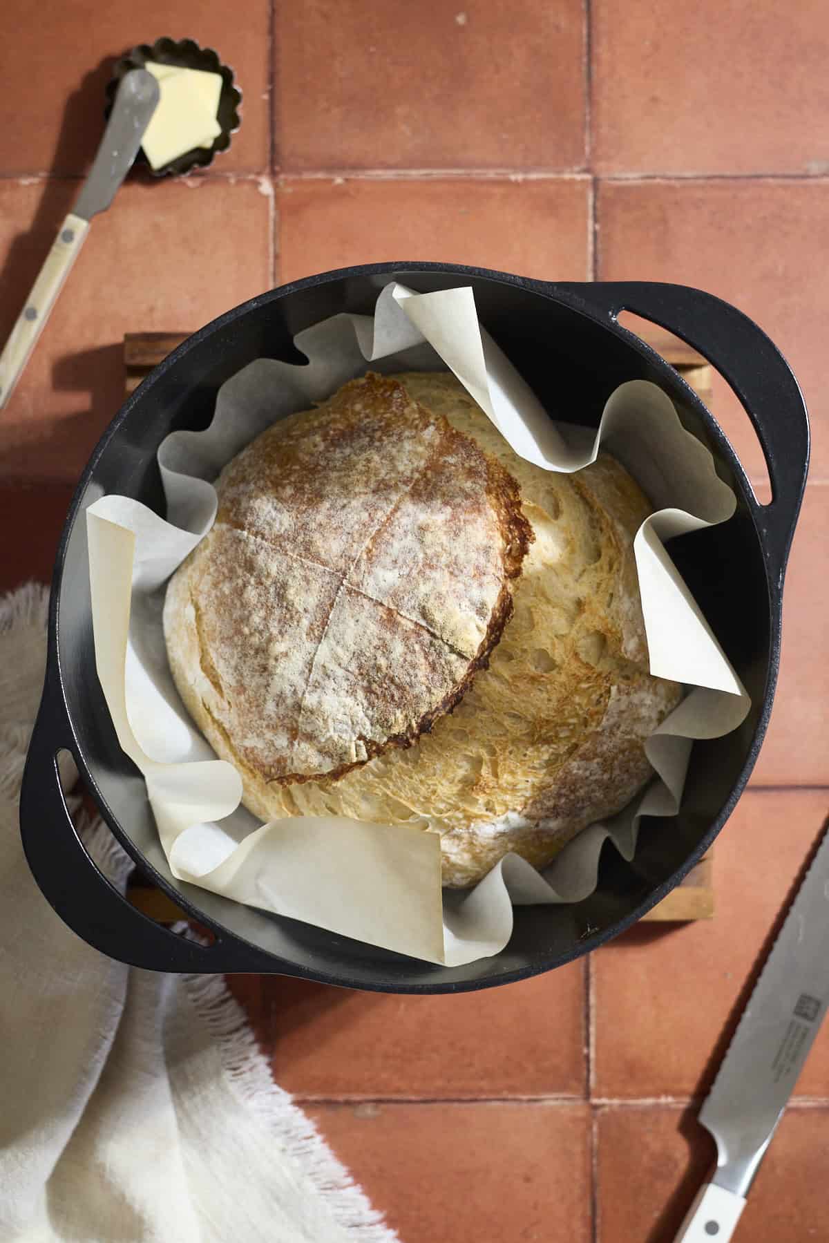 A baked sourdough loaf in a Dutch oven.