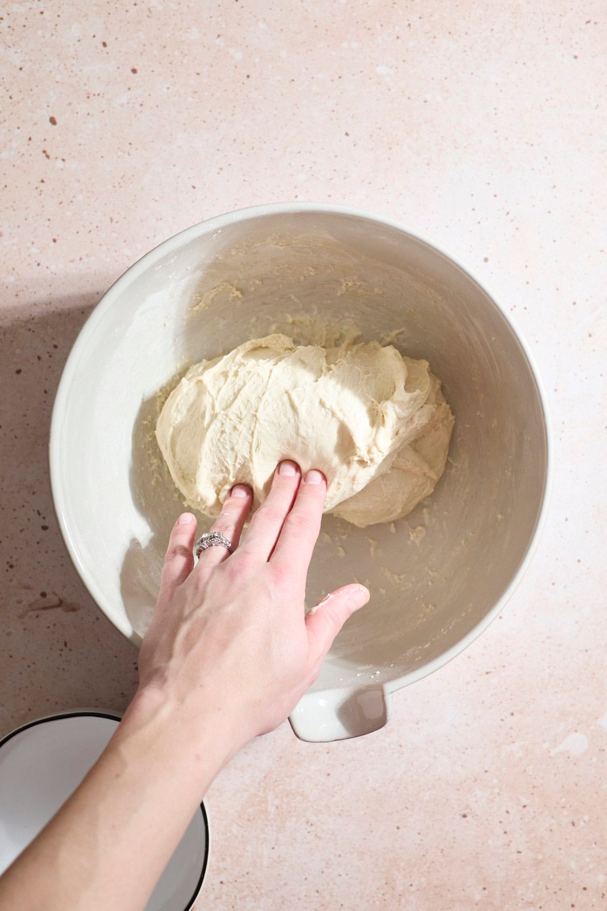 A hand folding the dough over onto itself.