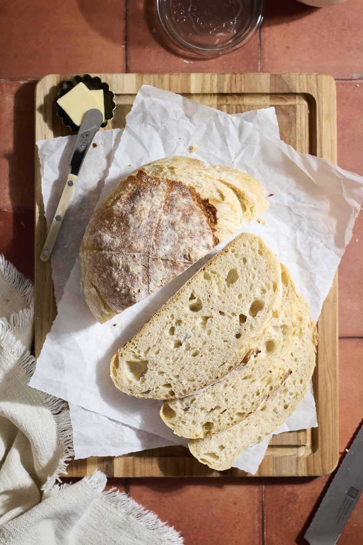 A sliced sourdough bread on a wooden cutting board.