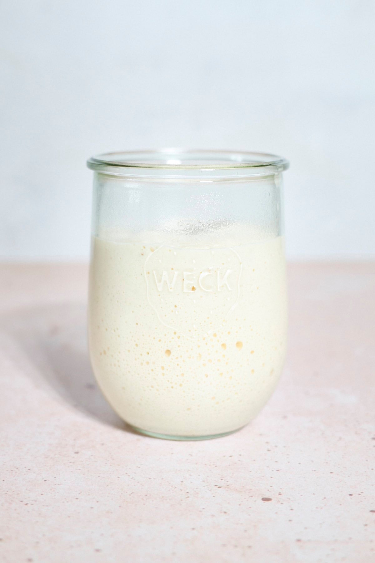Bubbly sourdough starter in a glass jar.