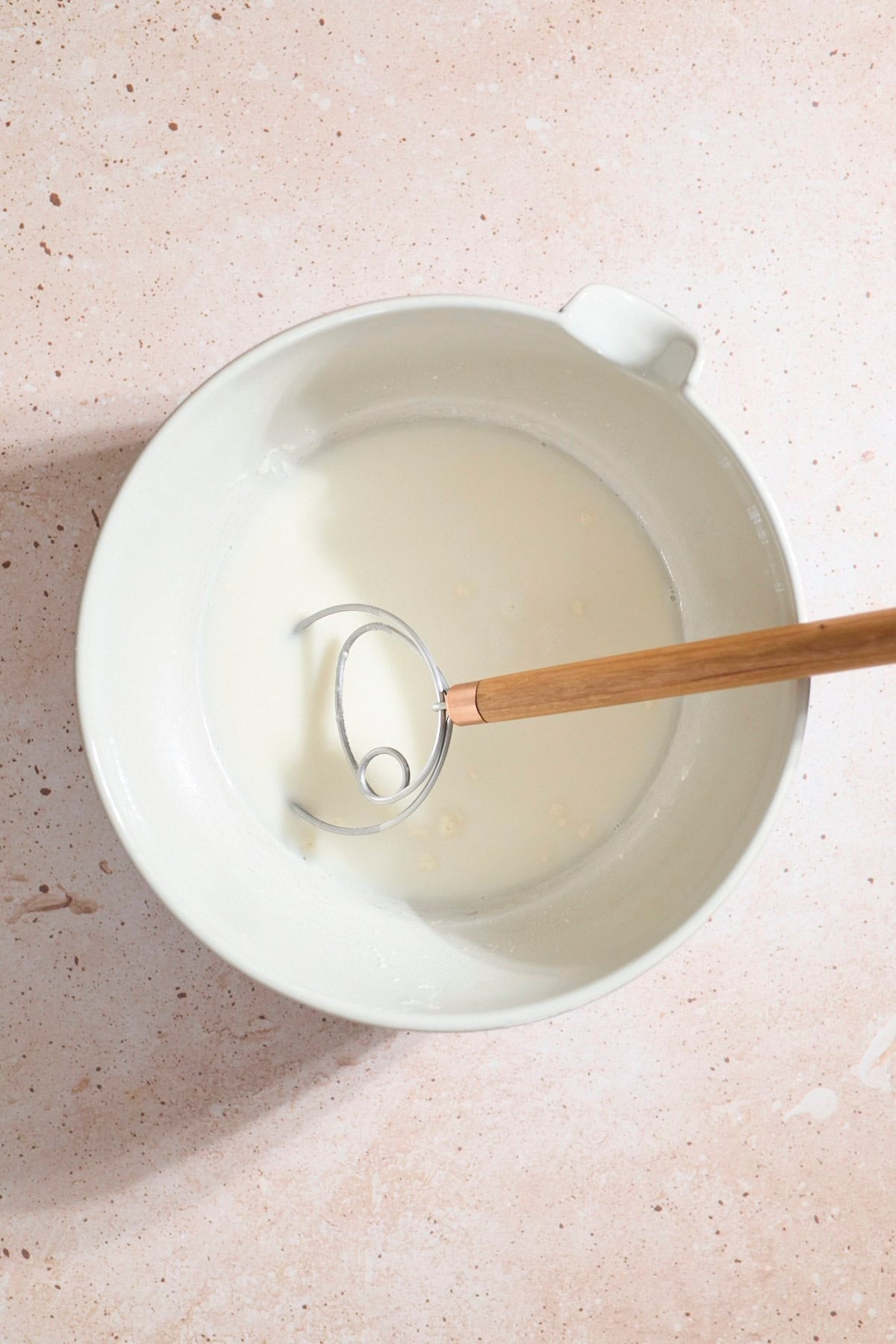 Water and sourdough starter mixed together in a large mixing bowl.