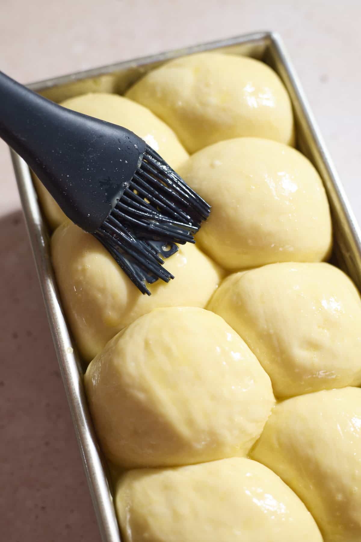 Brushing the dough with egg wash.