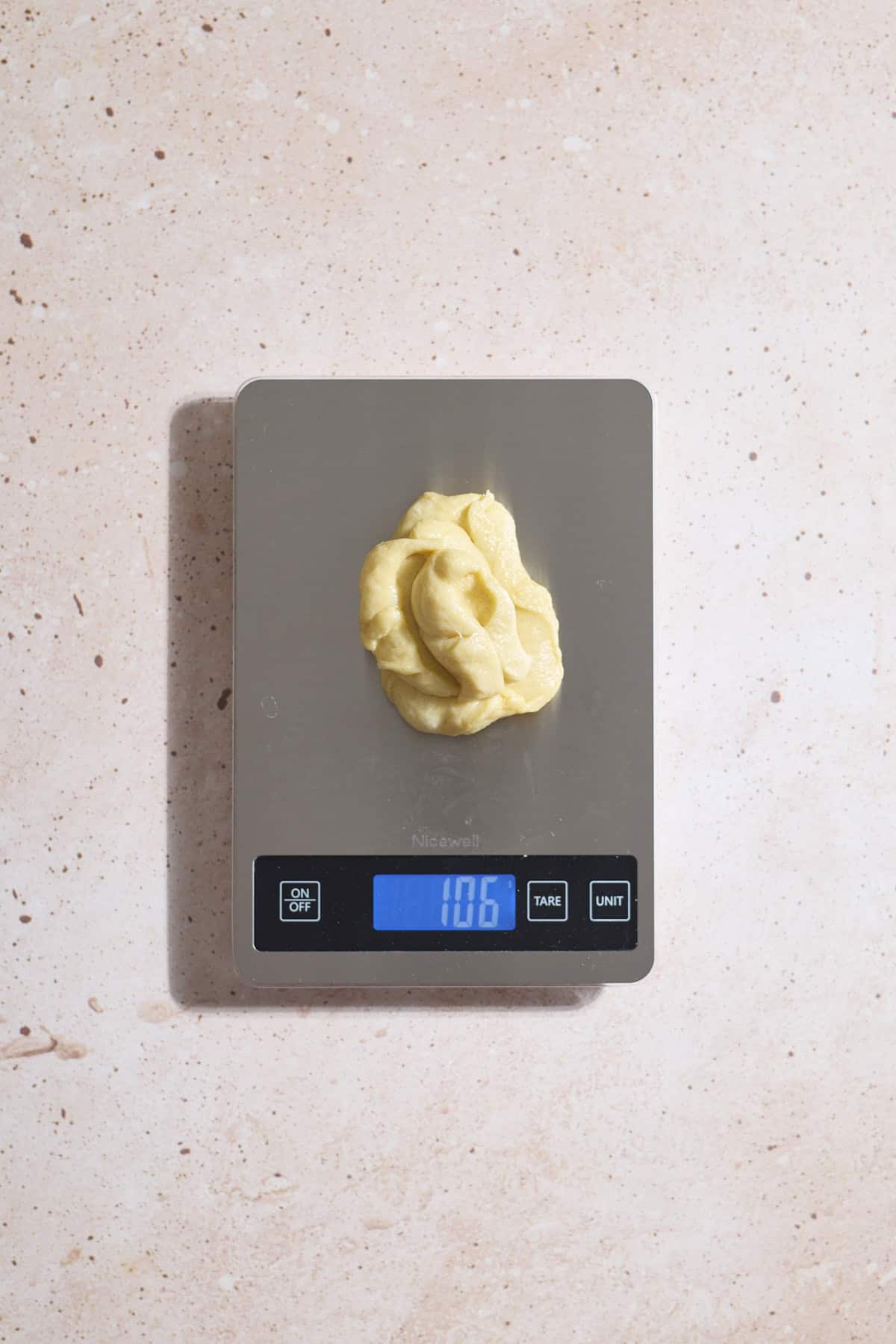 Dough being weighed on a scale.