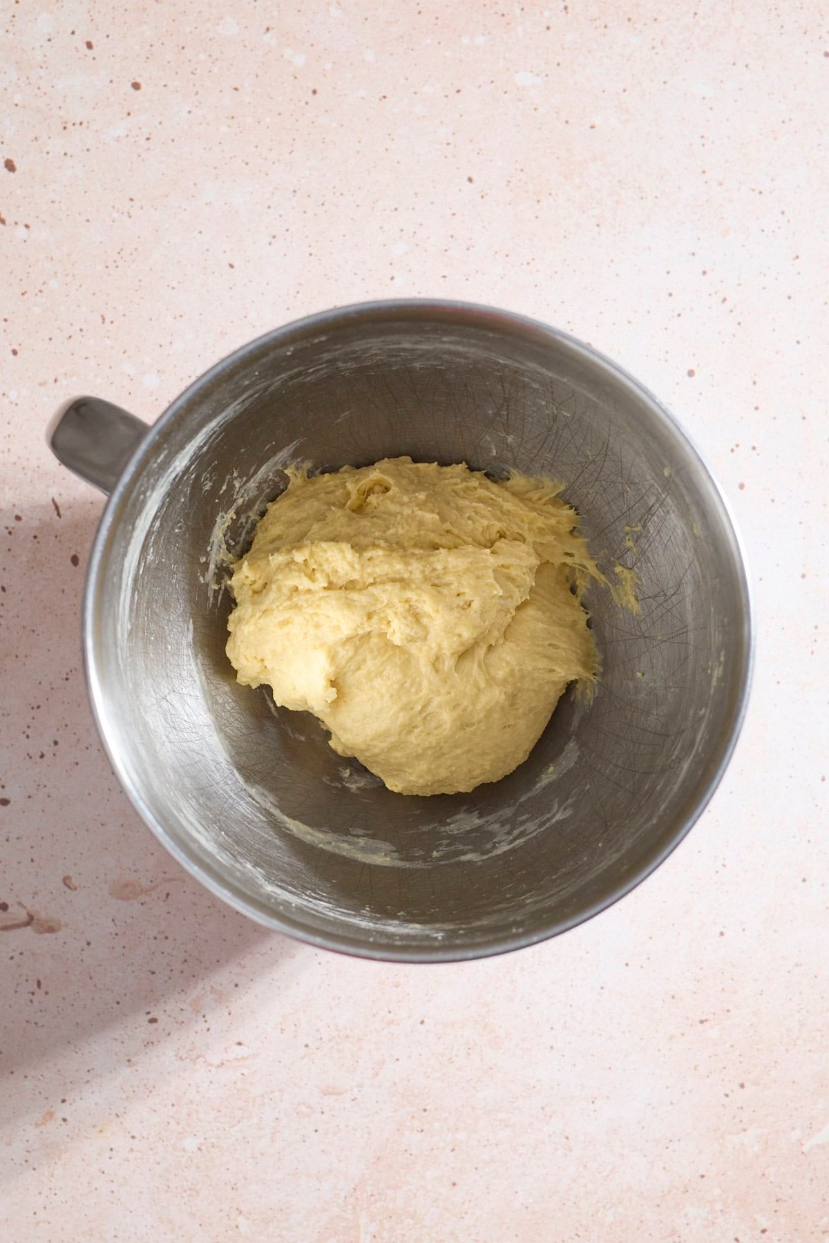 Shaggy dough in the bowl of a stand mixer.