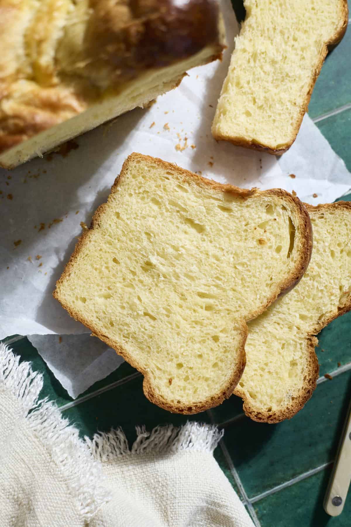 A slice of Sourdough Discard Brioche Bread on parchment paper.