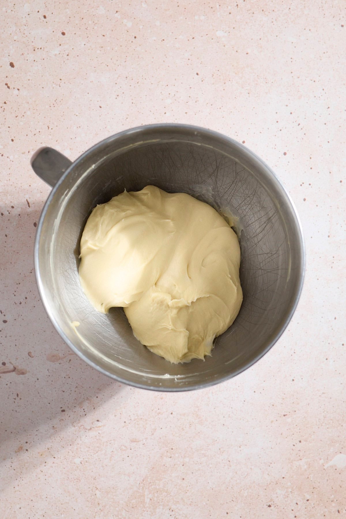 Smooth dough in the bowl of a stand mixer.