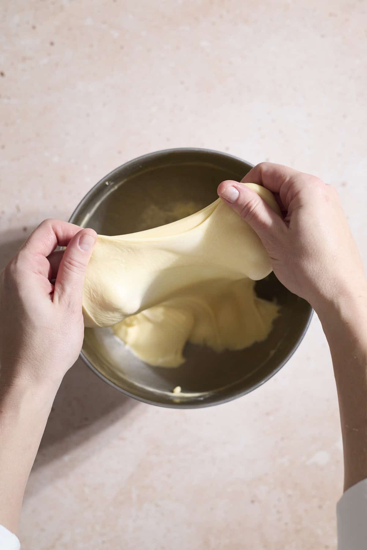 Dough being pulled to show the windowpane test.