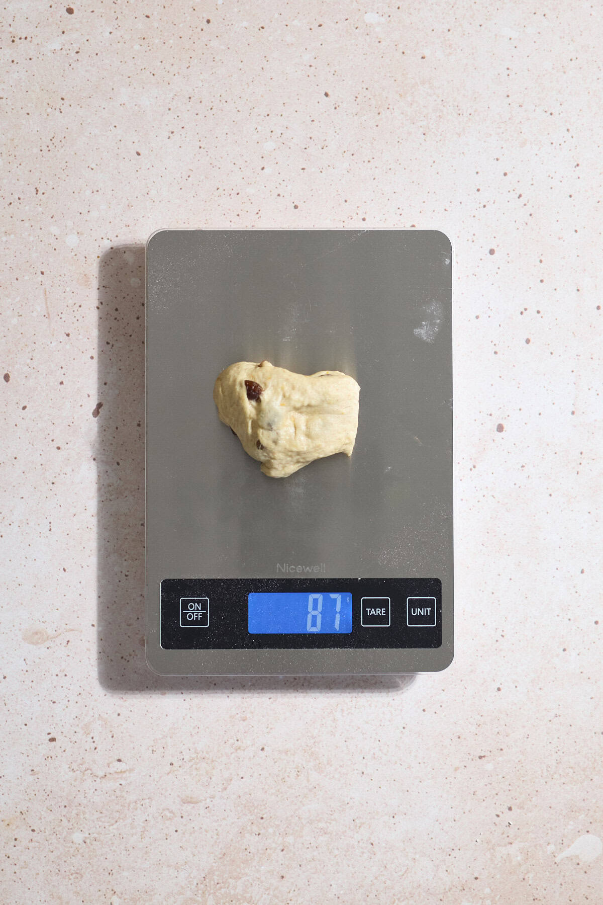Dough being weighed on a kitchen scale.
