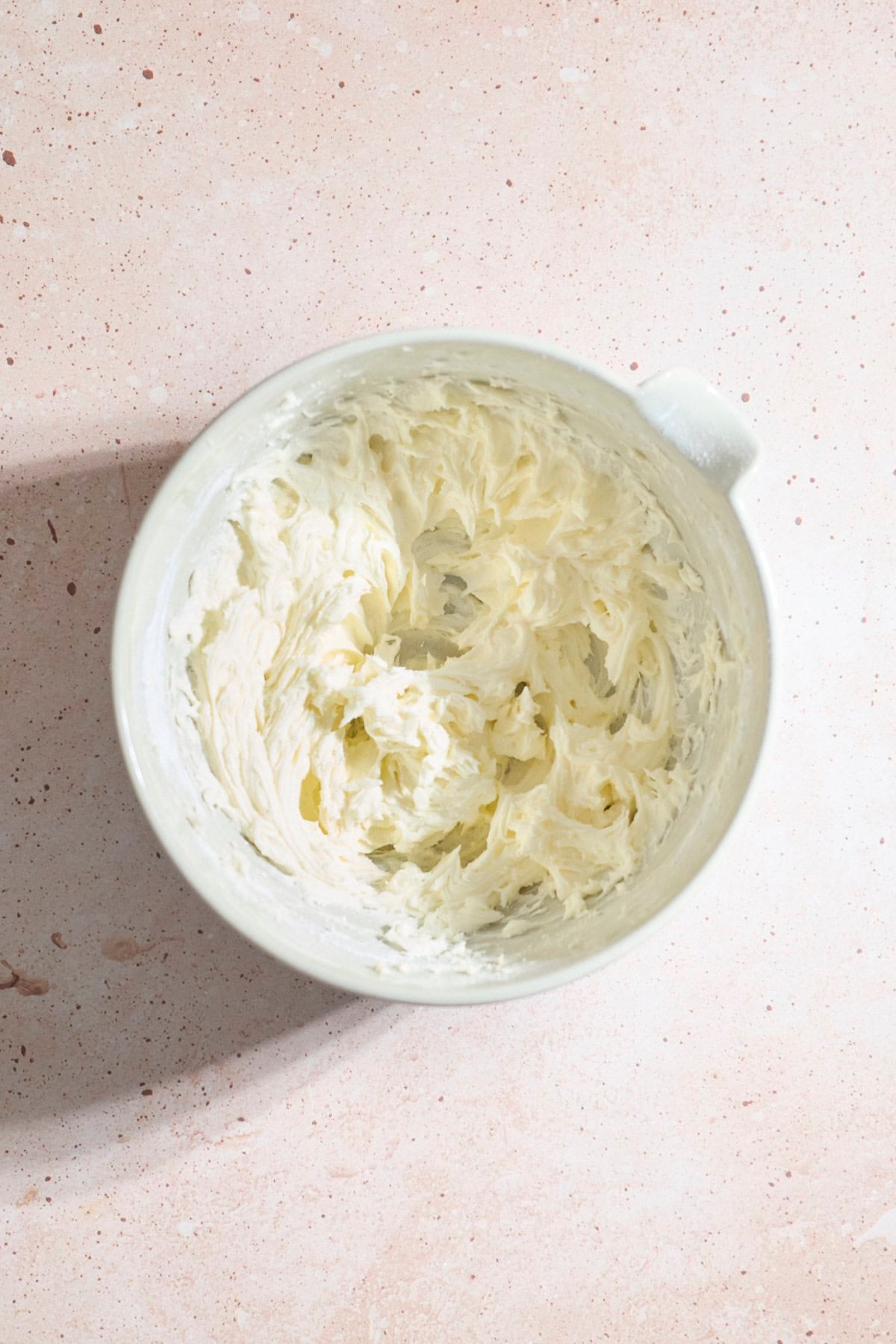 Frosting in a large white bowl.