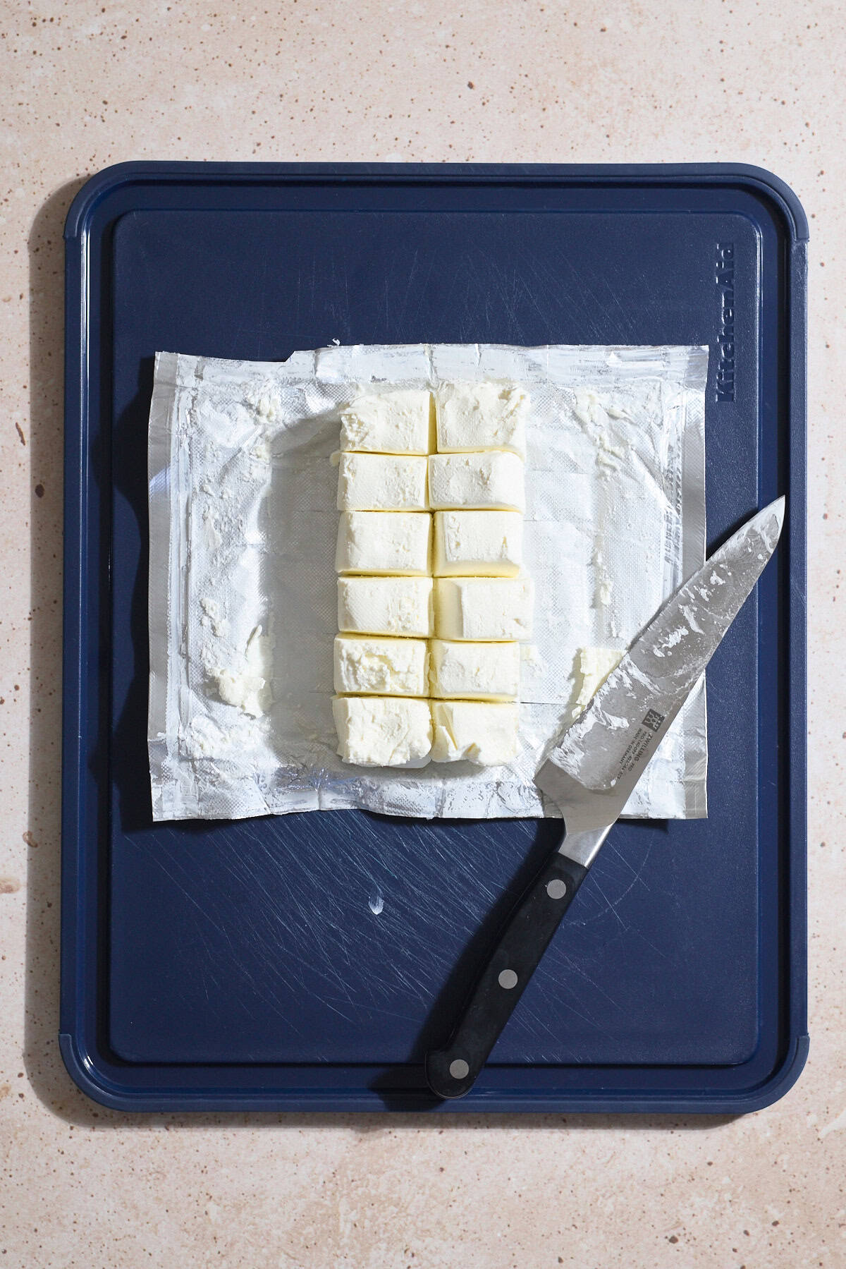 Cream cheese divided into 12 portions on a cutting board.
