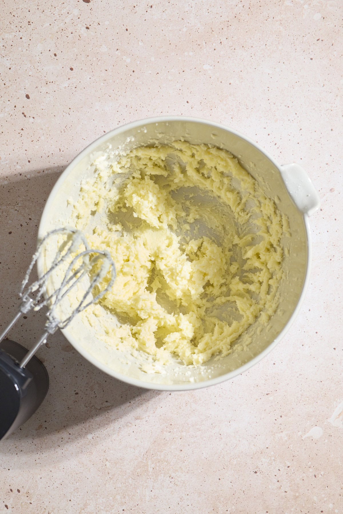 Butter and sugar creamed together in a mixing bowl.