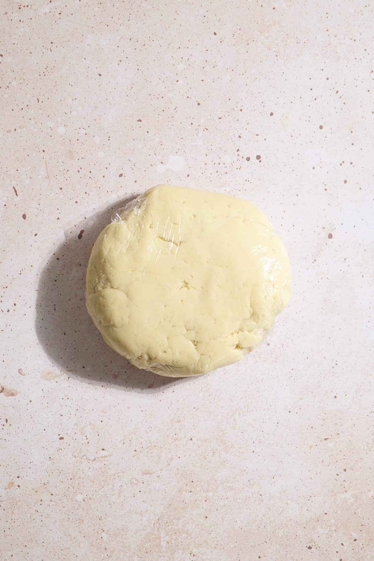 Cookie dough wrapped in plastic wrap for chilling.