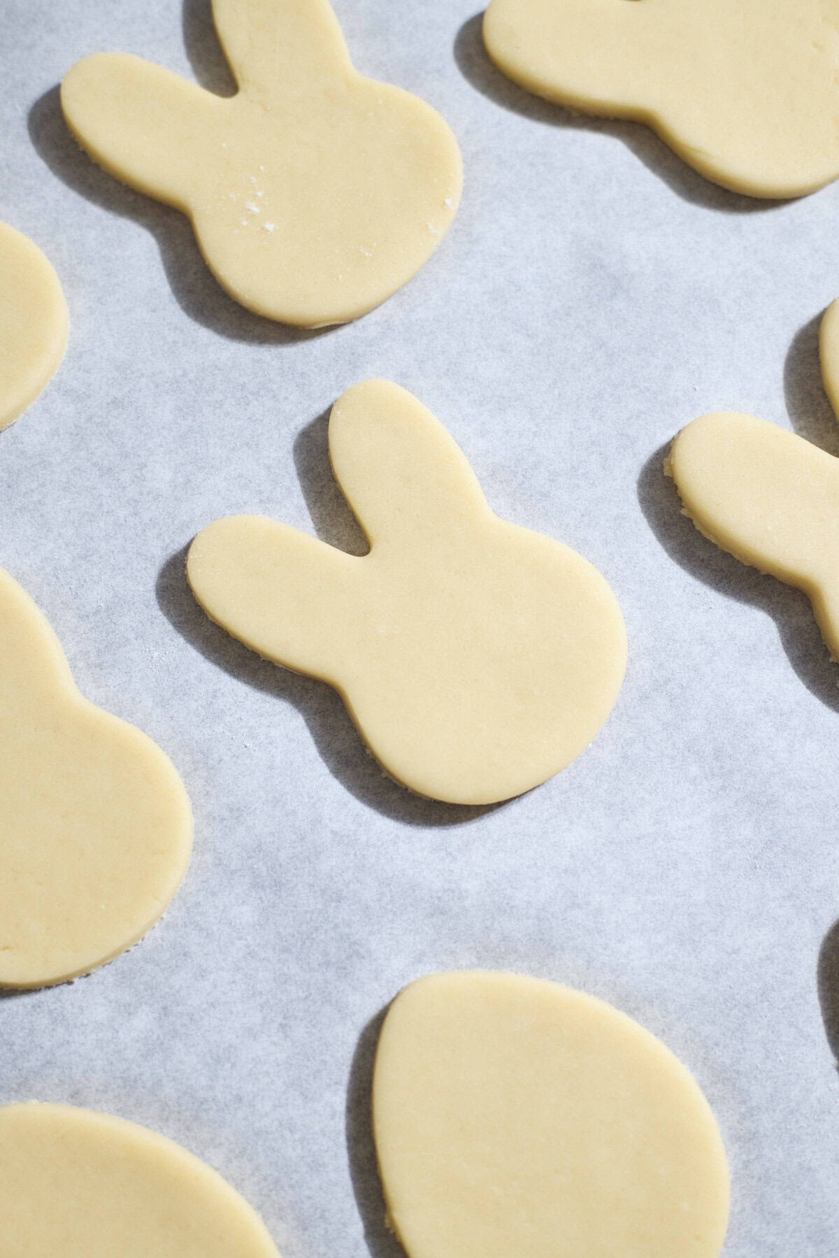 Cut out cookies on a baking sheet.
