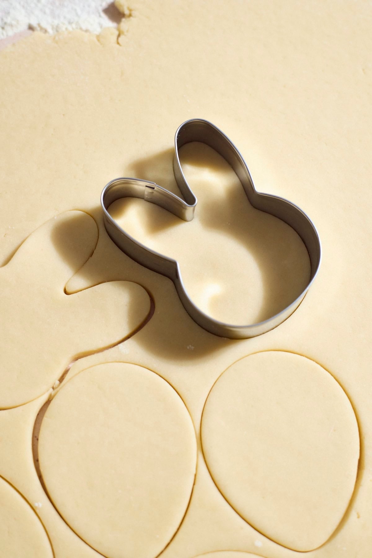 A cookie cutter pressed into the rolled cookie dough.