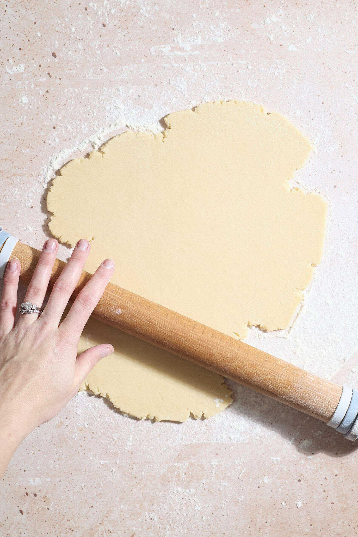 Dough being rolled with a rolling pin.