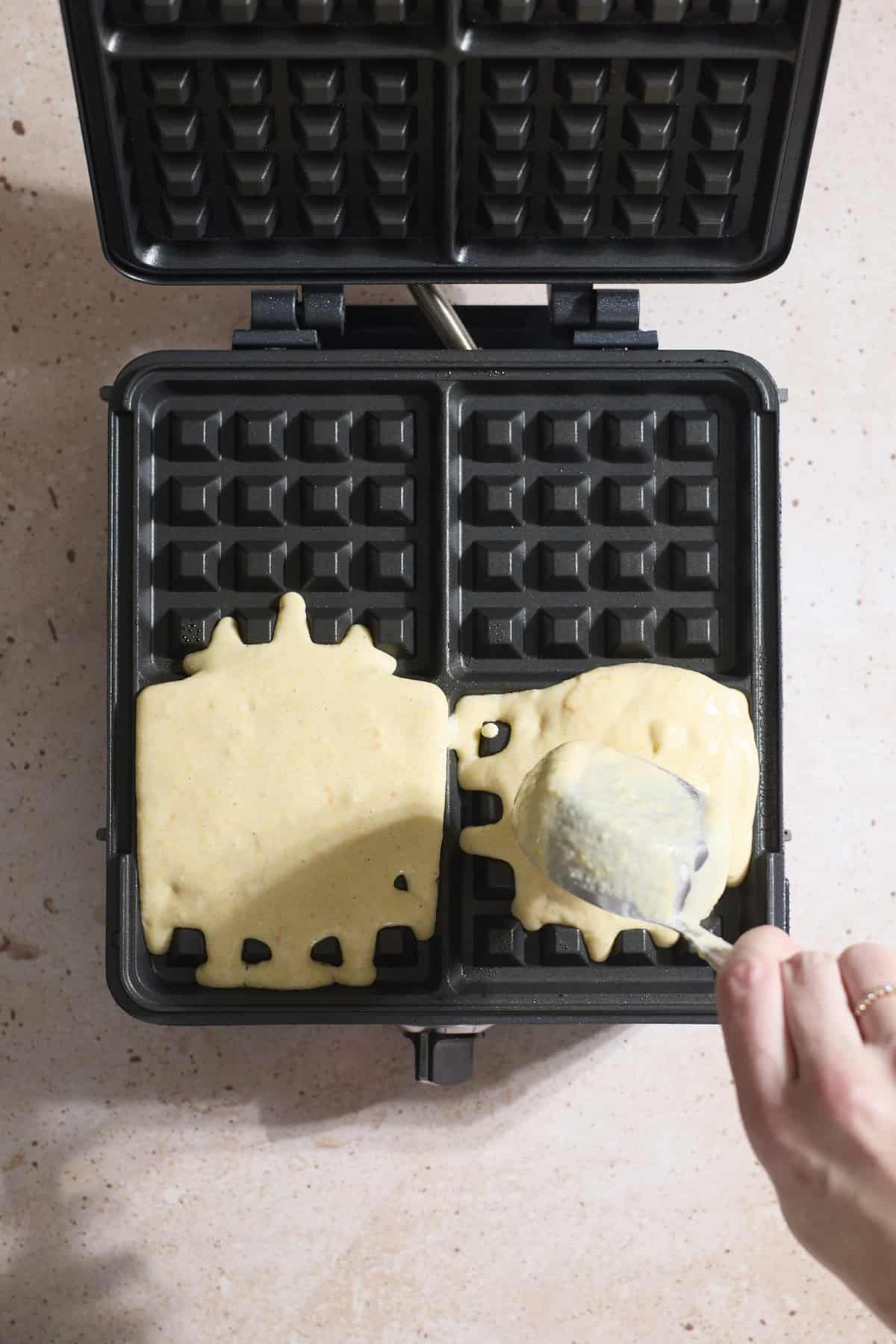 Batter being poured into a waffle iron.