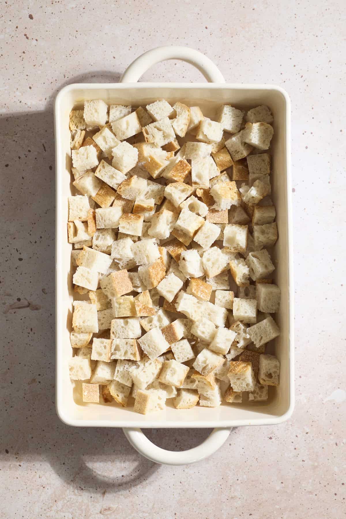 Cubed bread in a baking dish.