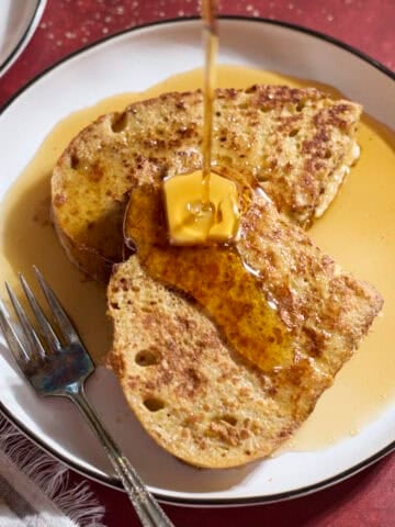 Syrup pouring onto a slice of Sourdough French Toast.