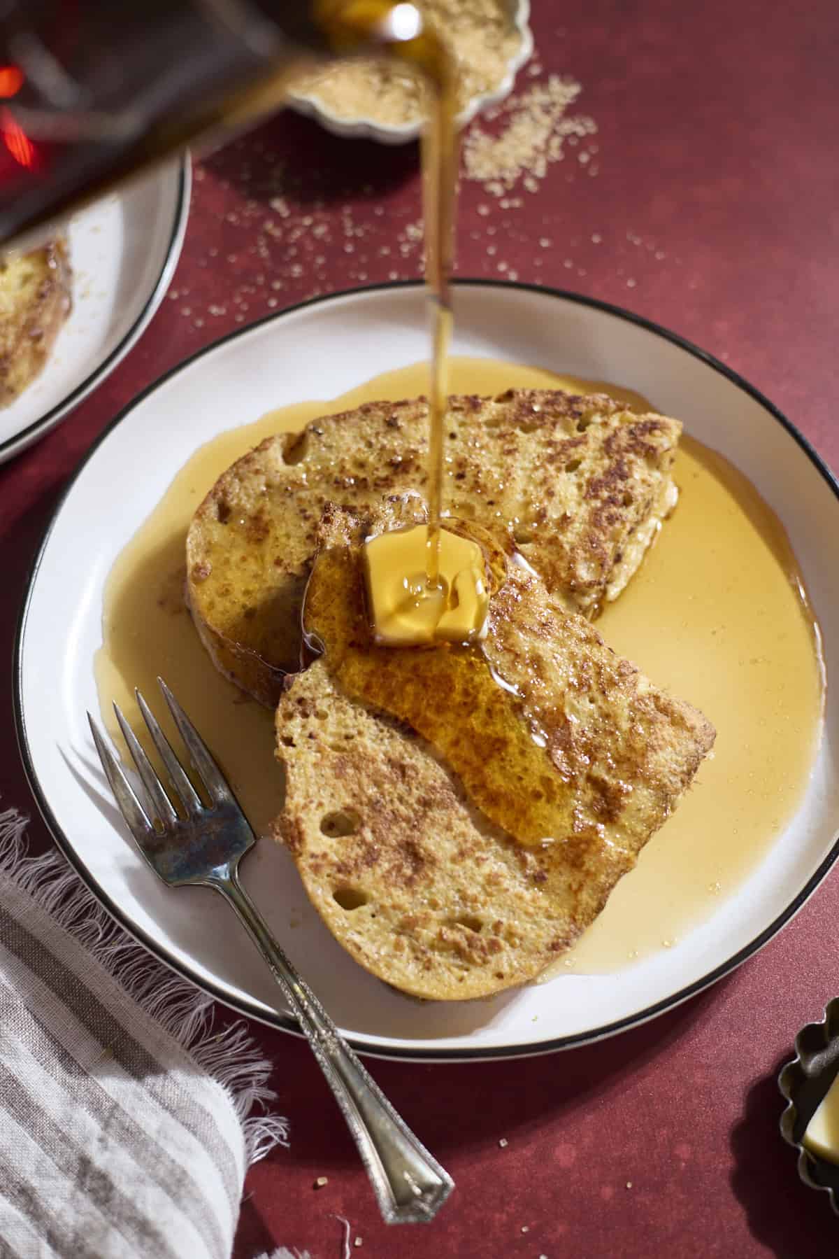 Syrup pouring onto a slice of French toast.