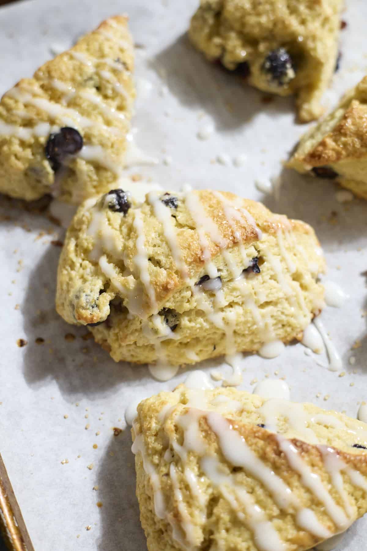 Sourdough Lemon Blueberry Scones on white parchment paper.