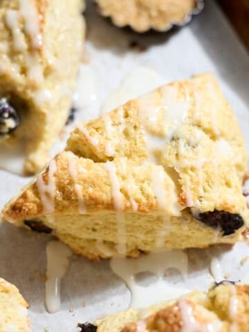 Sourdough Lemon Blueberry Scones on white parchment paper.