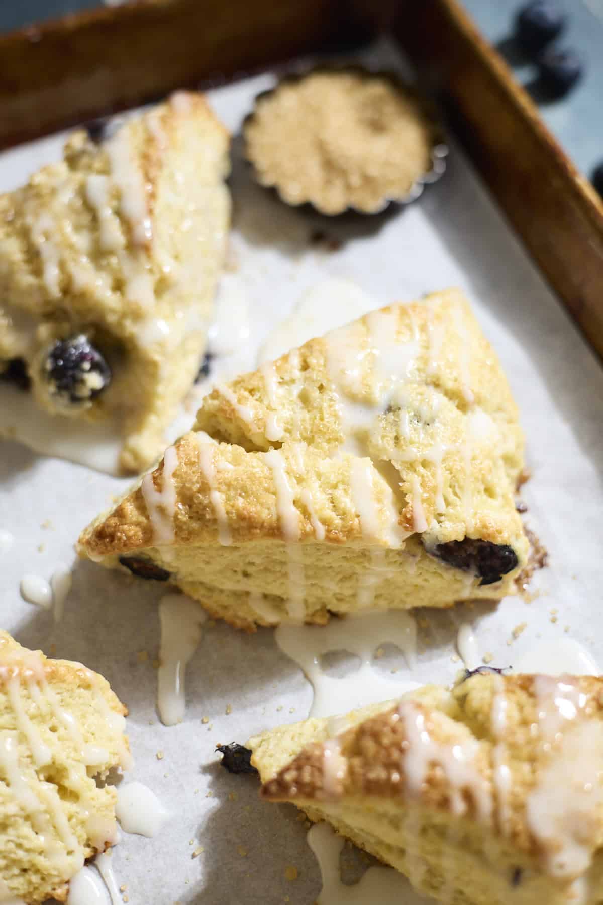 Sourdough Lemon Blueberry Scones on white parchment paper.