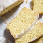 Slices of Sourdough Lemon Loaf Cake on white parchment paper.