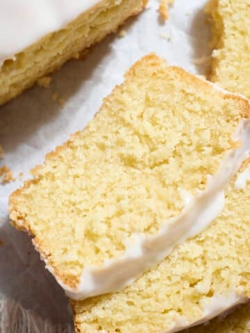 Slices of Sourdough Lemon Loaf Cake on white parchment paper.