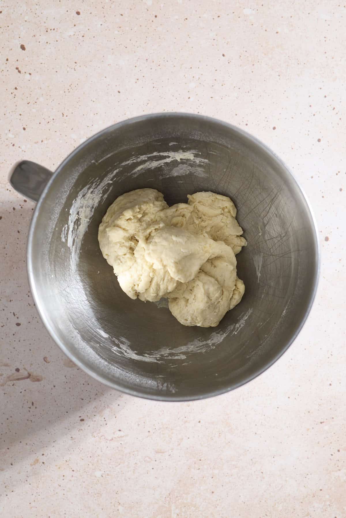 Dough in the bowl of a stand mixer.