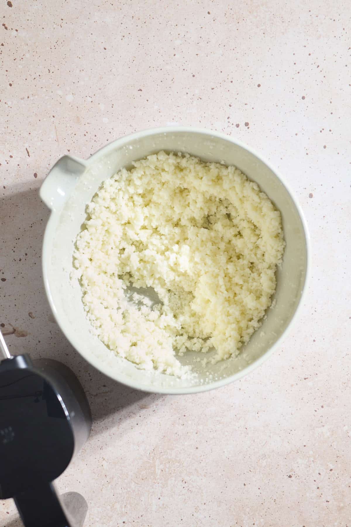 Butter and sugar creamed in a mixing bowl.
