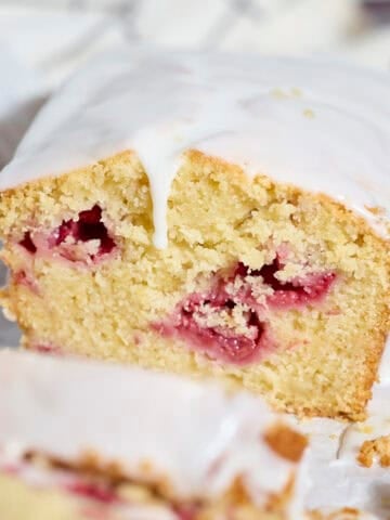 A slice of Sourdough Lemon Raspberry Loaf Cake.