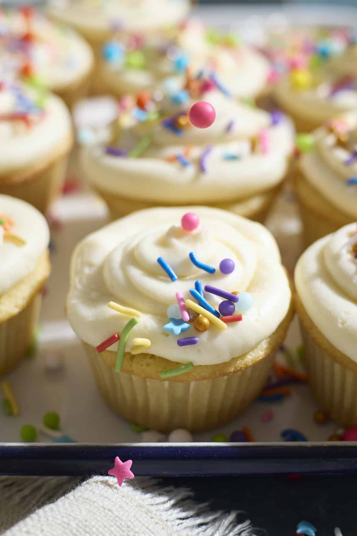Sprinkles being poured on the cupcake.