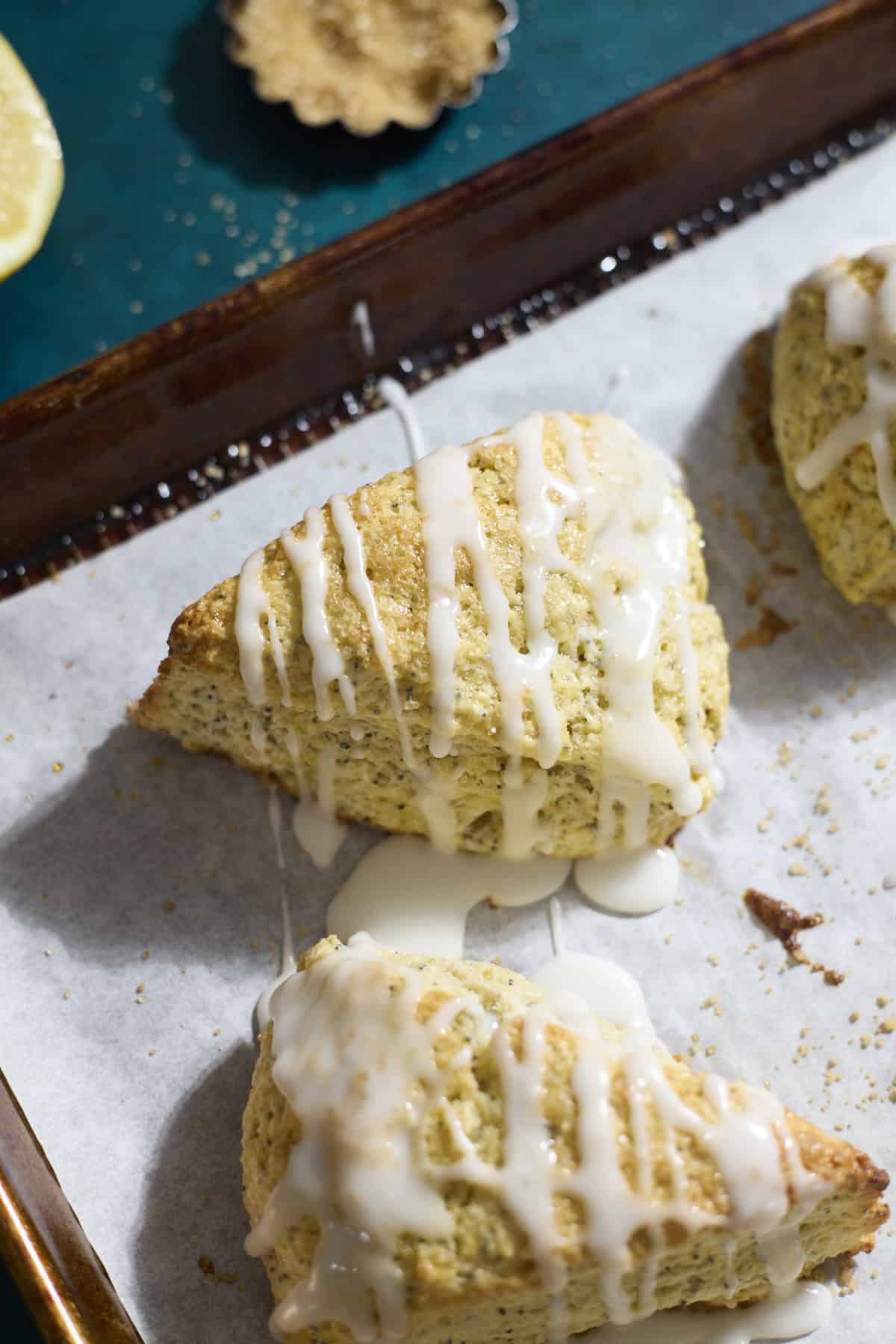 Sourdough Lemon Poppy Seed Scones on white parchment paper.