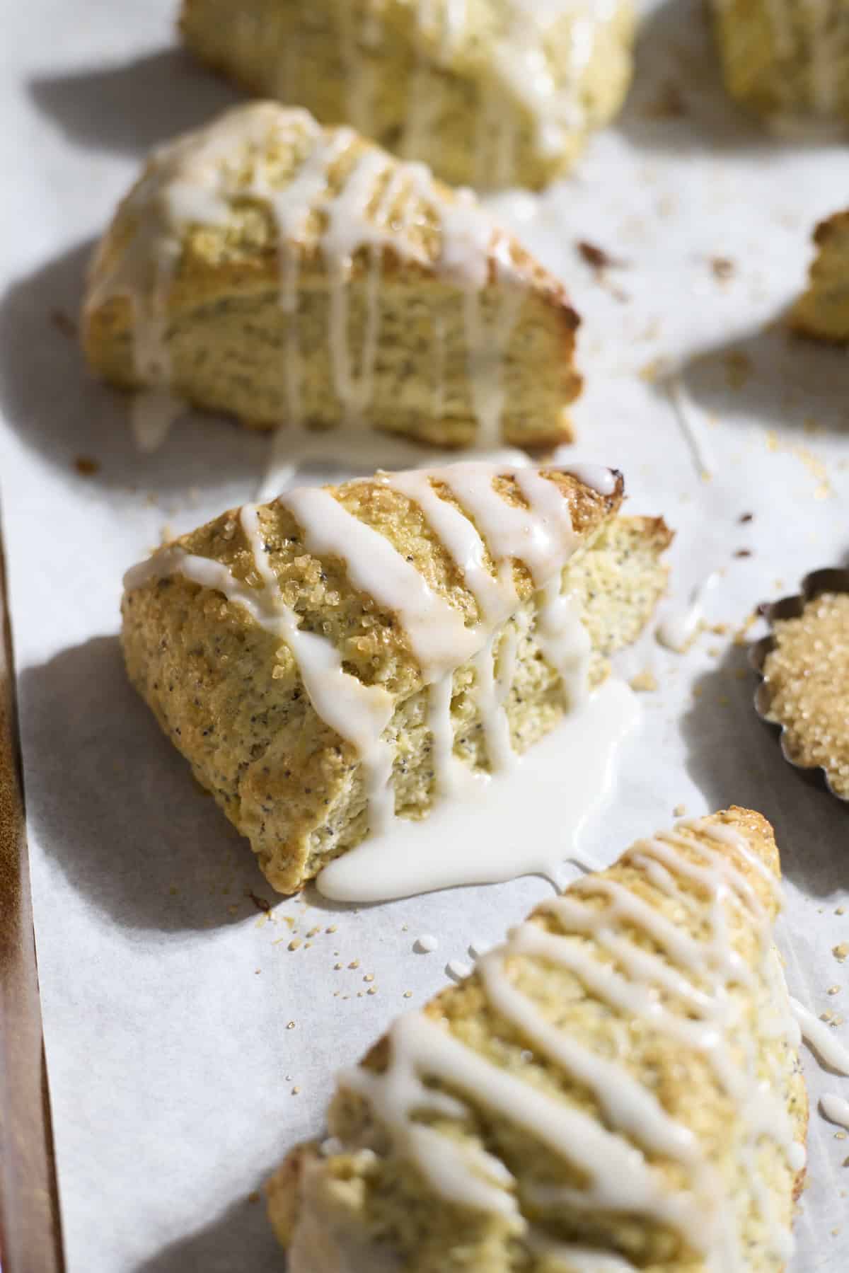 Sourdough Lemon Poppy Seed Scones on white parchment paper.
