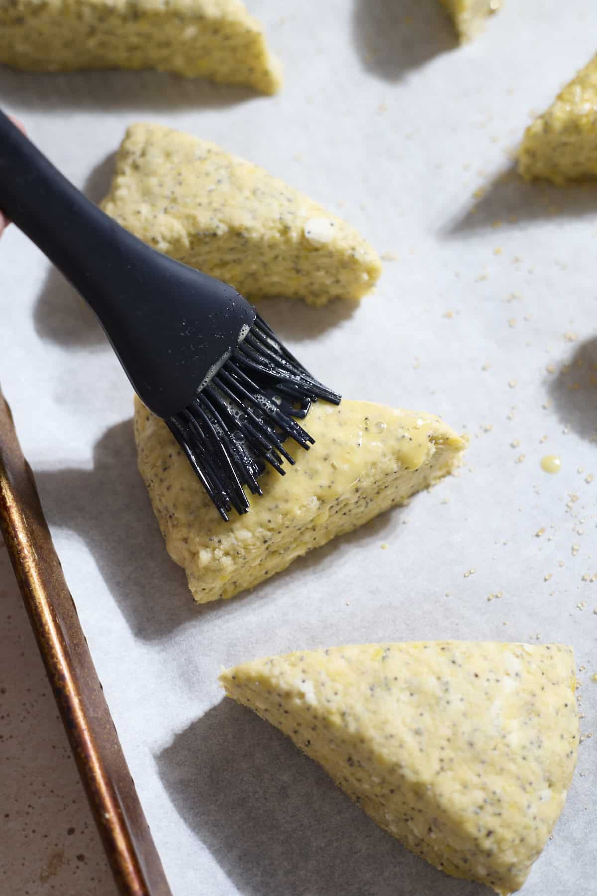 Scones being brushed with egg wash.