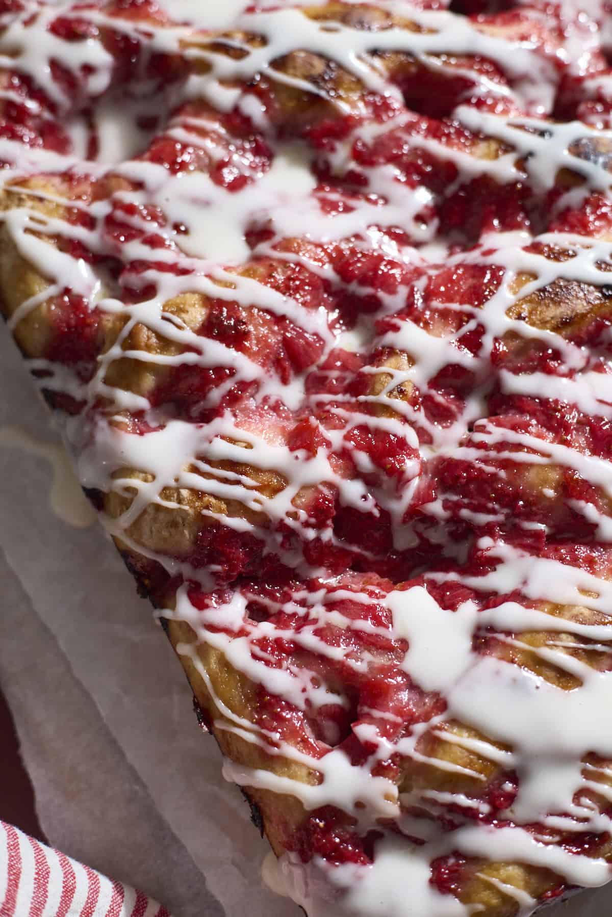 Sourdough Strawberry Donut Focaccia with icing drizzled on top.