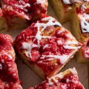 Slices of Sourdough Strawberry Donut Focaccia with icing drizzled on top.