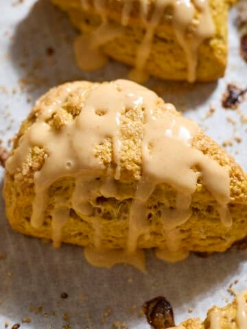 Sourdough Discard Pumpkin Scones with a drizzle of pumpkin glaze.
