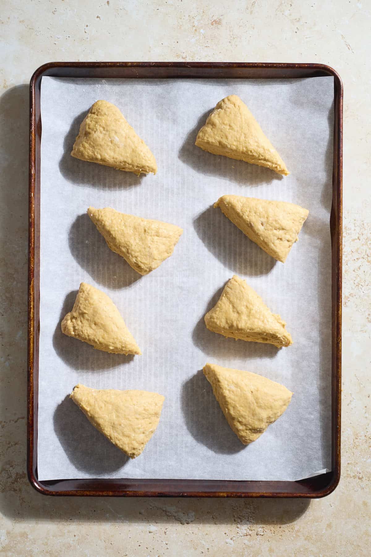Sliced scones on a baking sheet.
