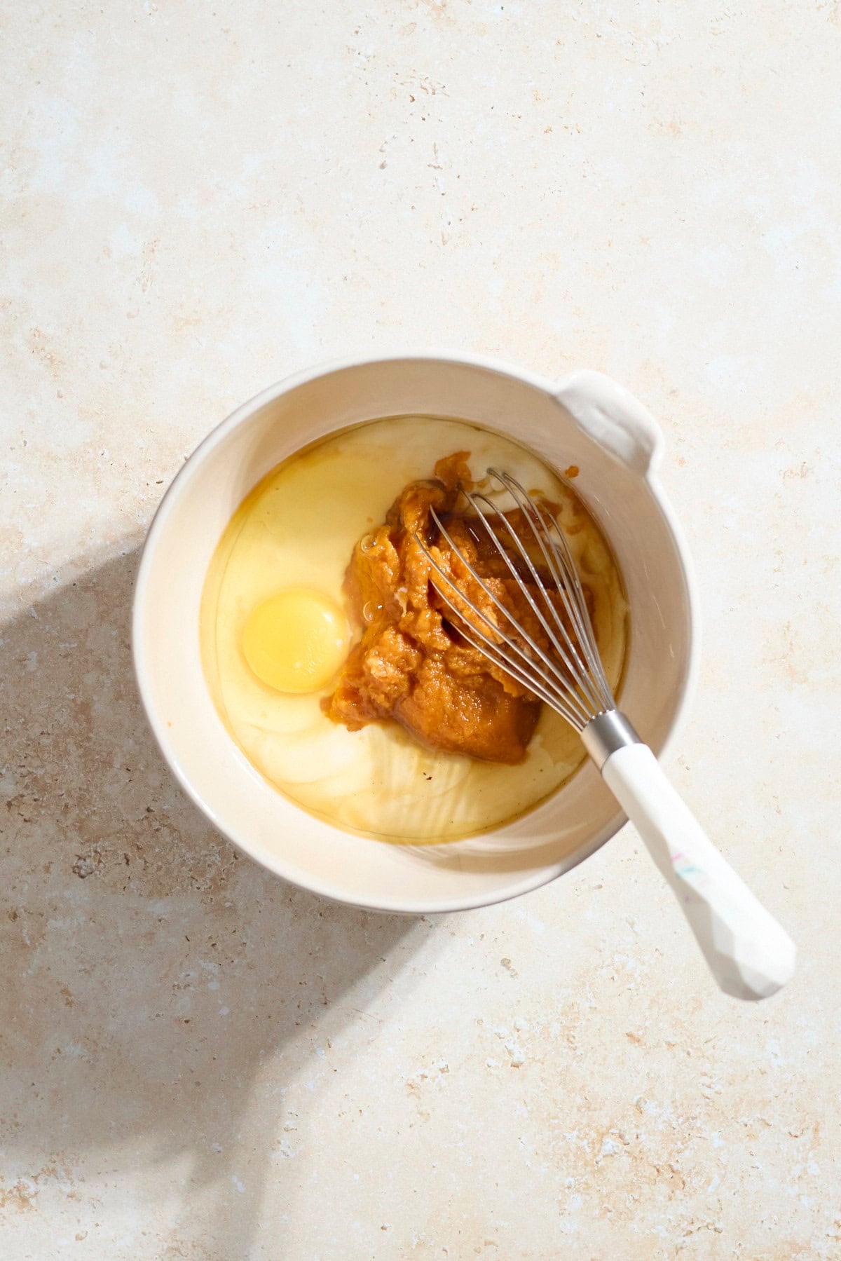 Wet ingredients in a mixing bowl with a whisk.