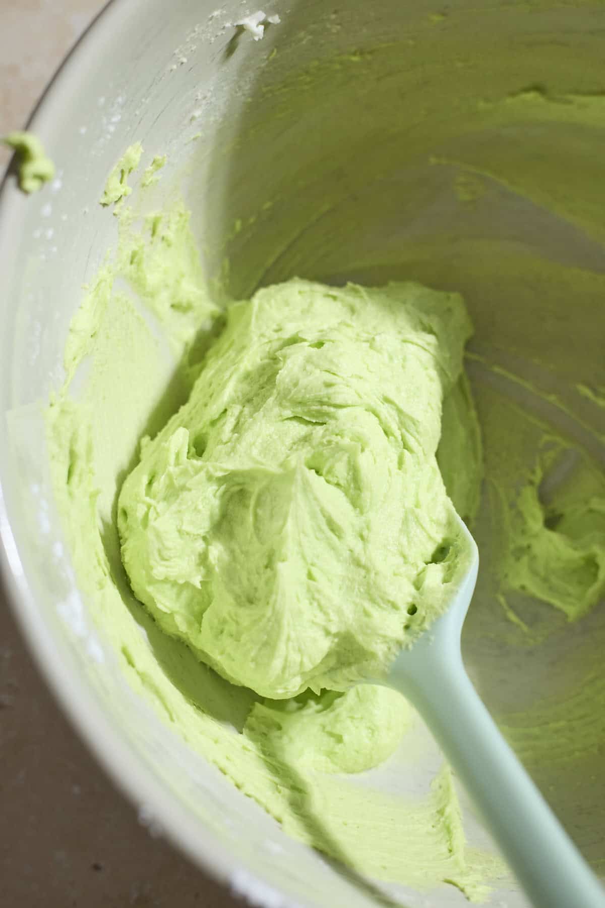 Green buttercream frosting in a bowl.