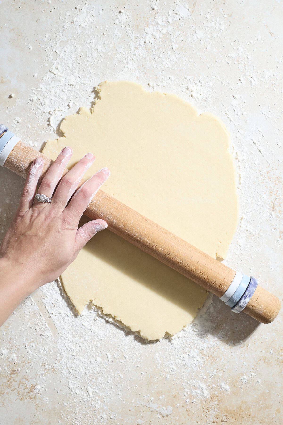 Cookie dough being rolled out with a rolling pin.